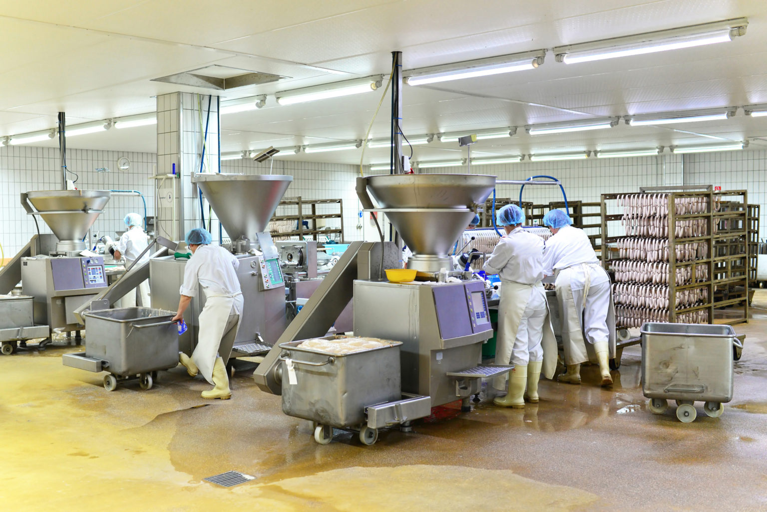 Arbeiter in einer Fleischerei bei der Herstellung von Würsten // Workers in a butcher's shop producing sausages